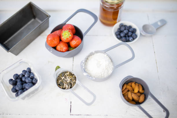 istock Berries, flour, and nuts in containers above white counter 1288858620
