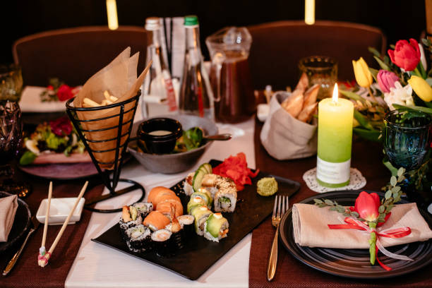 istock Sushi in a restaurant on a banquet table. Festive table setting with plates, cutlery and snacks. Elegant stylish table setting. 1288859624