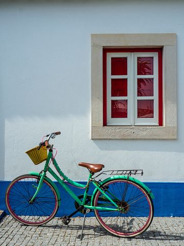 Old bike stop in front of a house with traditional Portuguese windows