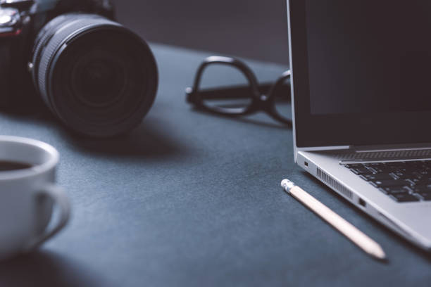 istock Laptop and camera on a desk 1288861230