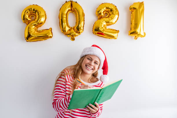 istock Studio shot of young woman writing new year resolutions 1288861306
