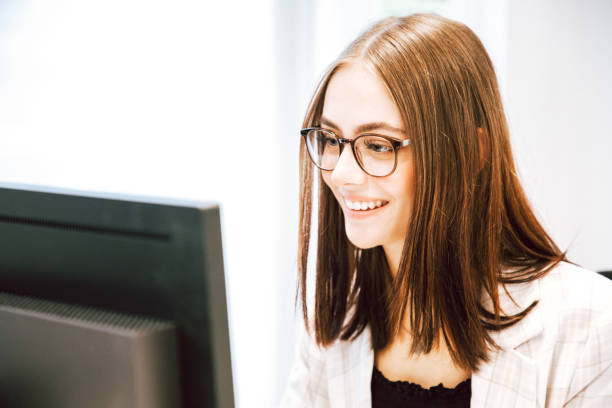 istock Happy smiling young businesswoman reading funny e-mails on her computer 1288862000