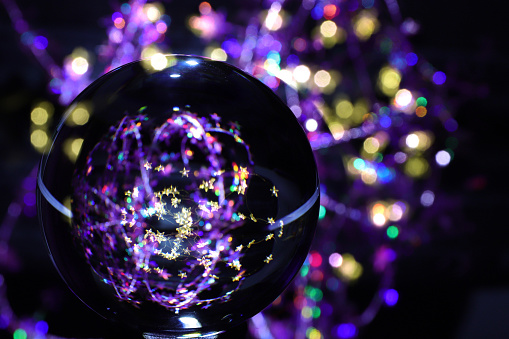 Crystal ball against colorful sparkling background.