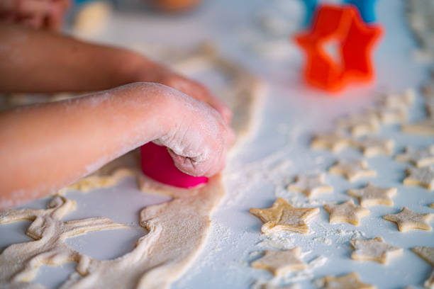 Star shaped raw cookies ready to bake. Baking sheet uncooked biscuits homemade cakes and ingredients on kitchen table. Homemade food preparing process. Household housewife housework concept