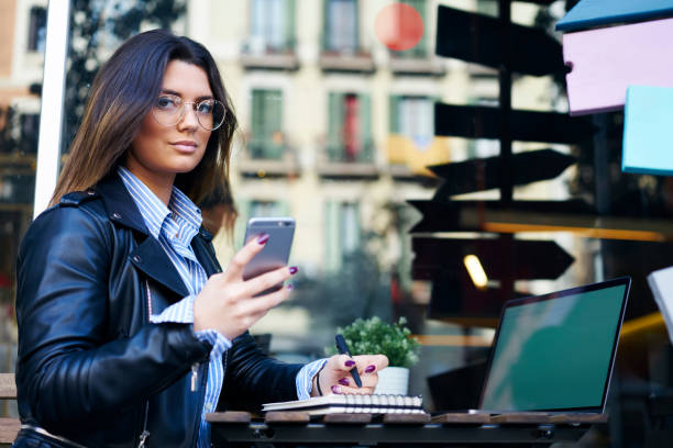 istock Businesswoman surfing smartphone while working from sidewalk cafe 1288871846