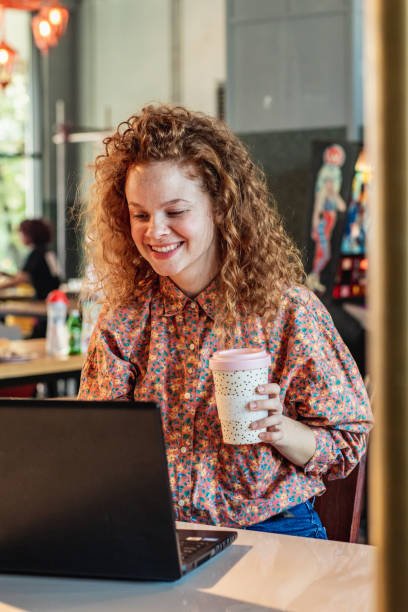 istock Young woman is working on laptop in cafe 1288872112