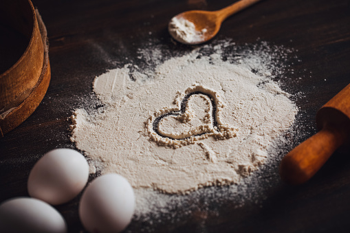 Making Heart Shape on the Flour on Rustic Wooden Table