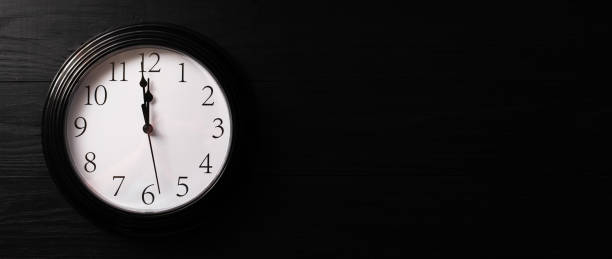 istock Clock on a black background. A minute to twelve. Banner. Place for your text. 1288874168