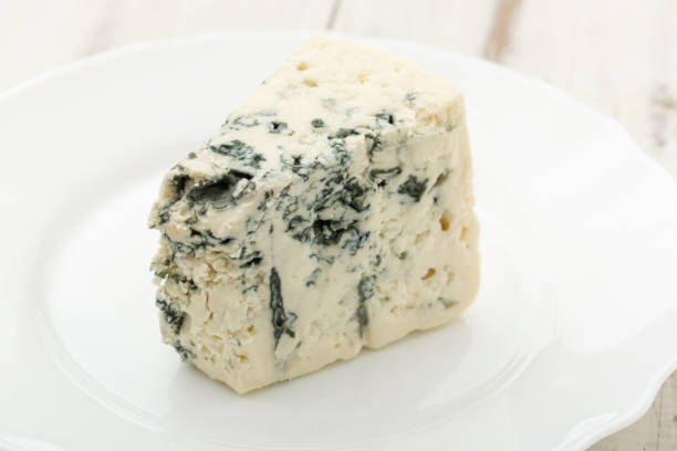 istock Blue cheese on a white plate on a wooden background. 1288874239