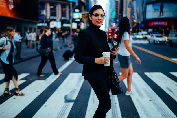 istock Elegant woman with coffee walking on crosswalk 1288874475