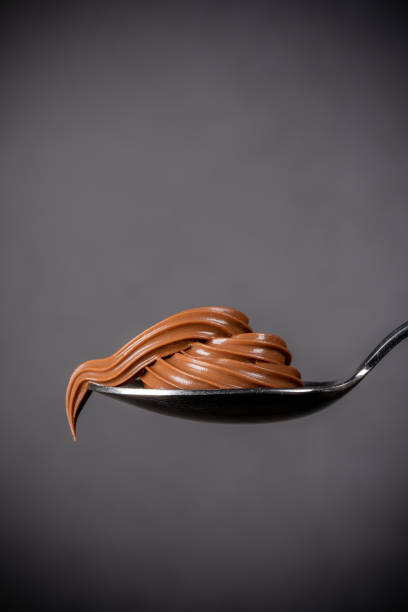 istock Cream chocolate in spoon on black background 1288875522