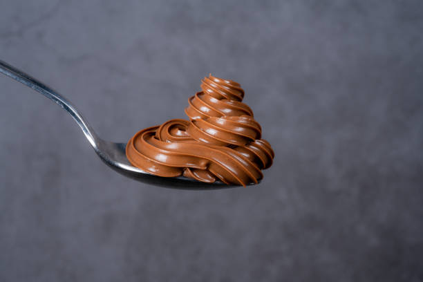 istock Cream chocolate in spoon on black background 1288875568