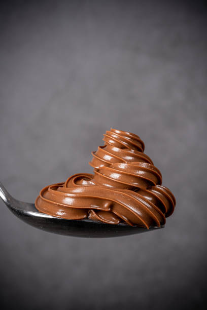 istock Cream chocolate in spoon on black background 1288875617