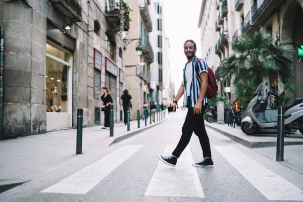 istock Cheerful ethnic man crossing road in old town 1288876092