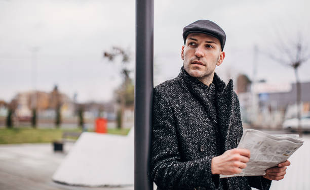 istock Modern man reading newspaper on the street 1288878760