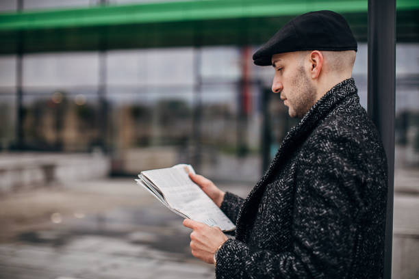 istock Modern man reading newspaper on the street 1288878886