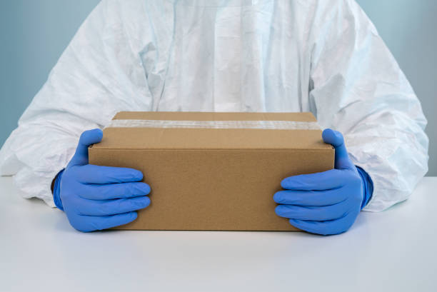 istock A nurse in a protective suit shows a box with both hands in a hospital. Covid 19 1288879130