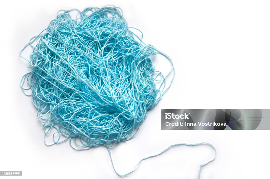 The concept of brainstorming. A tangle of mint, blue cotton threads, needlework yarn on a white background. Tangled Stock Photo