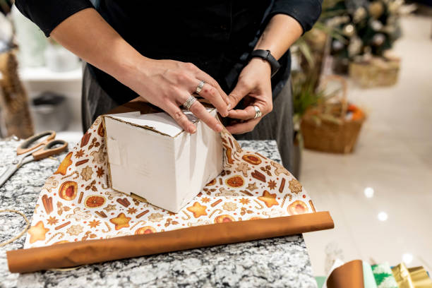 istock Preparing for Christmas holidays. Female hands wrapping gift box 1288881383