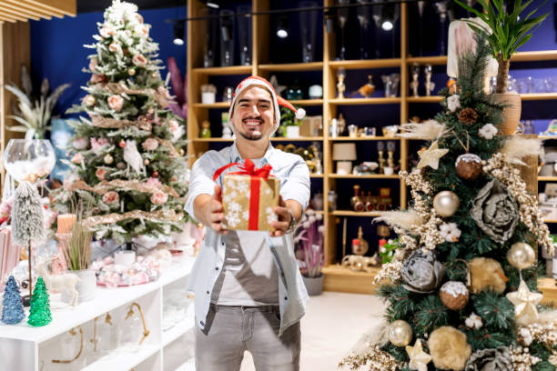 istock Smiling man in Santa hat with gift boxes. 1288881413