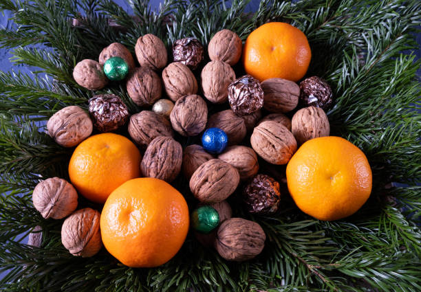 istock tangerines, sweets and nuts on the table on spruce branches, on a blue background 1288882470