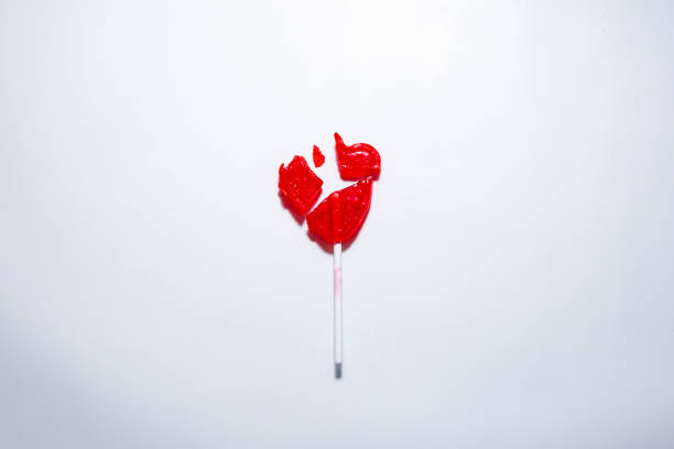 Cenital plane. A heart-shaped lollipop in the center is broken into several pieces. Heartbreak concept, broken heart.