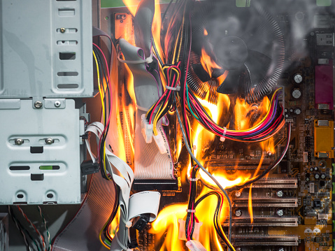 Fire destroying the motherboard and components of a desktop PC.