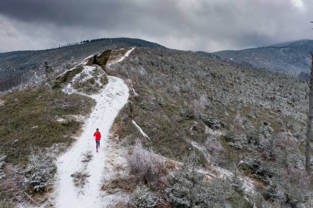 Aerial view on a runner in a red sweatshirt on a beautiful mountain winter trail. Aerial view on a runner in a red sweatshirt on a beautiful mountain winter trail. Winter landscape. beskid mountains photos stock pictures, royalty-free photos & images