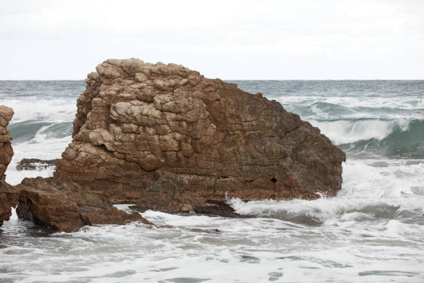 Rock formation and waves at beach.Rugged and rocky coastal scenic with rough surf.