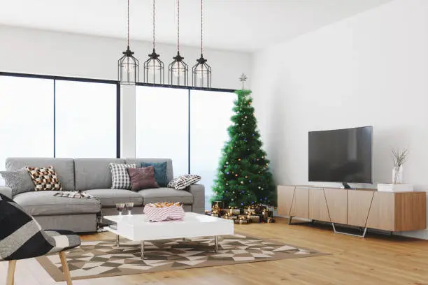 Interior of a modern, bright and airy living room with Christmas tree.