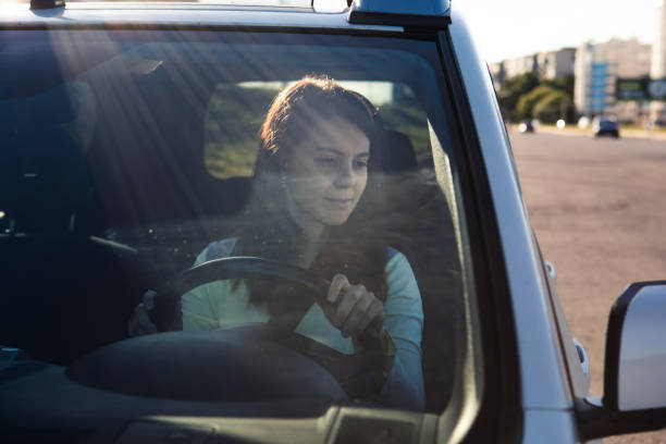 istock young pretty smiling woman driving car 1288887278