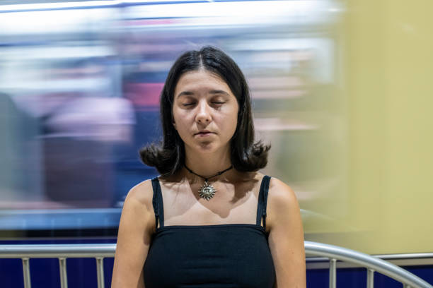 Portrait of a young girl with closed eyes. A train is passing behind her.
