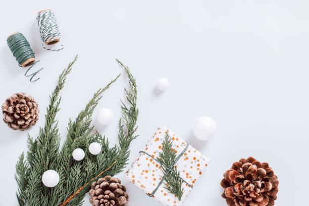 istock White minimal Christmas border with christmas tree branch, decor and cones, flat lay, copy space, web banner 1288888386