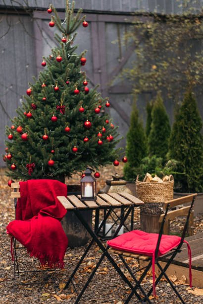 gatucafé under julgran med röd inredning utomhus. träbord och stolar med varm pläd på vintermarknaden i trädgården. mysig festlig och nyårsstämning. filmeffekt. selektivt fokus - julfika bildbanksfoton och bilder