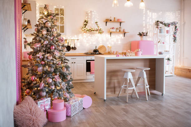 Modern Kitchen Interior with Island, Sink, Cabinets in New Luxury Home Decorated in Christmas Style. Modern Kitchen Interior with Island, Sink, Cabinets in New Luxury Home Decorated in Christmas Style. Image with grain pink christmas tree stock pictures, royalty-free photos & images