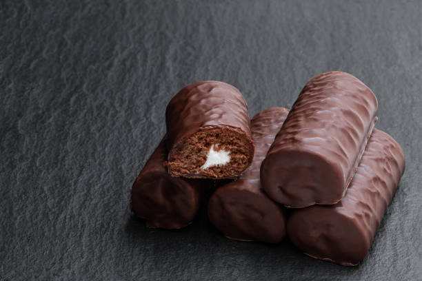 istock Chocolate sponge cake covered with milk chocolate on black stone background 1288890036