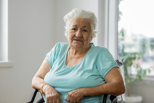 Senior woman sitting in wheelchair at home