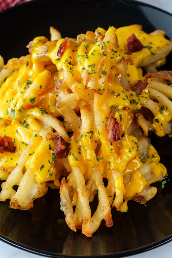 Crispy waffle fries loaded with bacon and melted cheddar cheese sauce