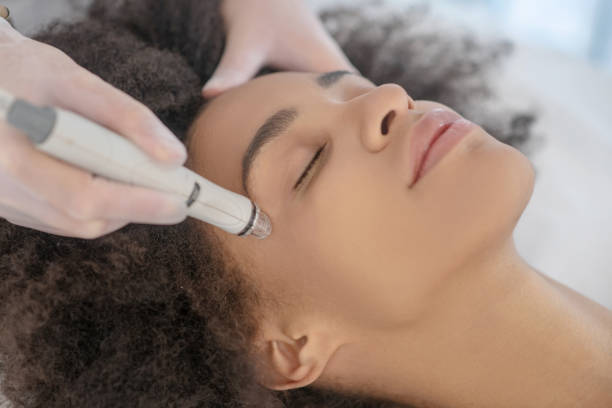 istock Doctor hands performing hardware cosmetic procedure on girl face 1288893518