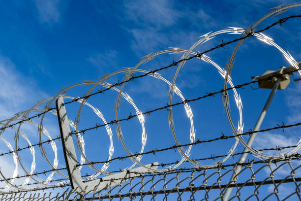 istock Close up of razor wire on a security fence 1288895747