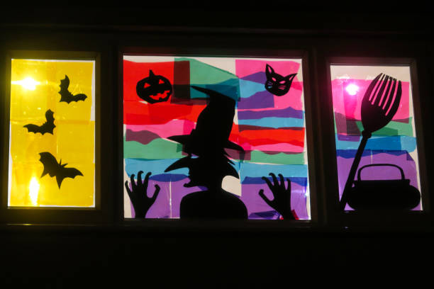 ハロウィーンシーンの窓絵の画像、バット、大釜、ほうき、カボチャと猫が窓ガラスに描かれた背中の魔女シルエット、ティッシュペーパーステンドグラス効果アート - glass autumn halloween food ストックフォトと画像