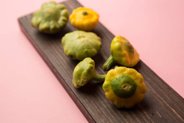 istock A bowl full of yellow and green Mini squash on a pink backdrop 1288897182