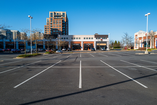 Reston, VA, USA -- November 29, 2020. Photo of a nearly empty parking lot for a strip of retail stores in Reston Town Center.