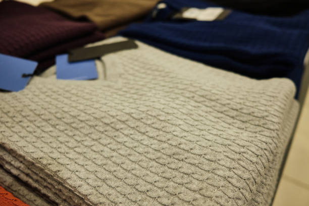 istock Men knitted sweaters in pastel colors stacked on store counter 1288898116