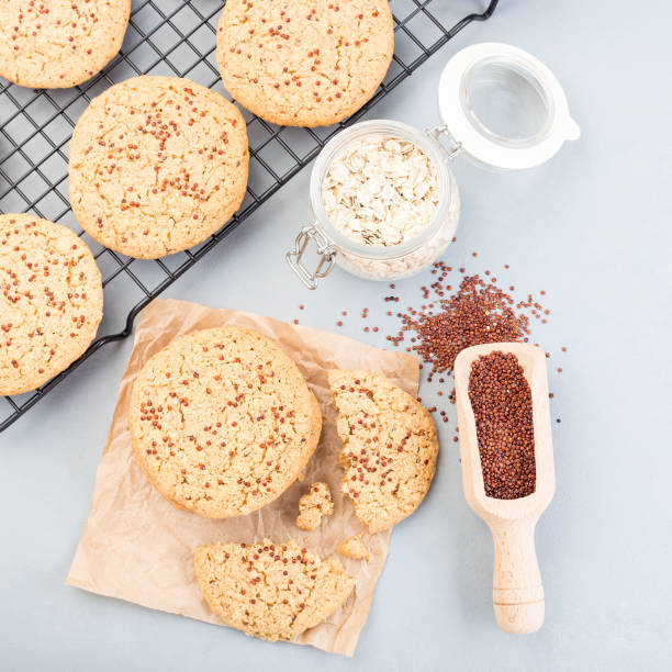 istock Oatmeal and red quinoa cookies on a table and cooling rack, top view, square 1288899878