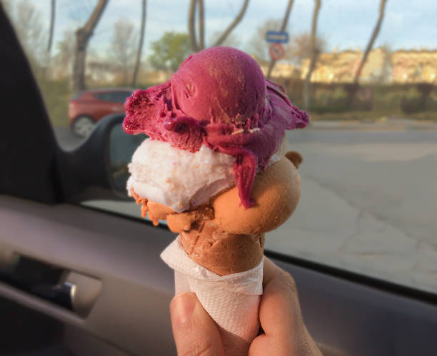 холдинг конус с 3 различных вкус красочных мороженого в автомобиле в летний день - melting ice cream cone chocolate frozen стоковые фото и изображения