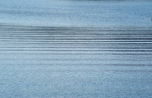 istock Horizontal waves across gentle cool blue water 1288903076