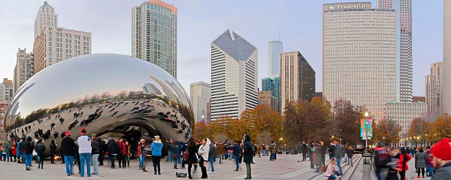 Chicago, USA - December 8, 2018:  Michigan Boulevard district skyscrapers - also known as Michigan Avenue “streetwall” - facing Grant Park and the many visitors of Cloud Gate during the holiday season.