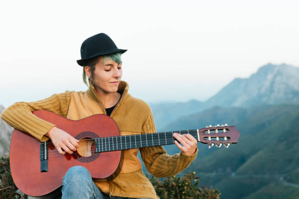 istock young woman playing guitar in the mountains 1288905319