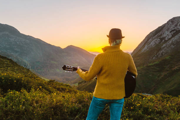 young woman playing guitar in the mountains - quility imagens e fotografias de stock